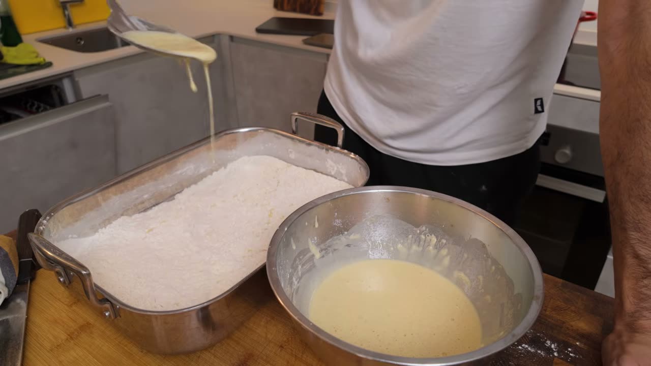 Goteando la masa sobre la harina para hacer grumos