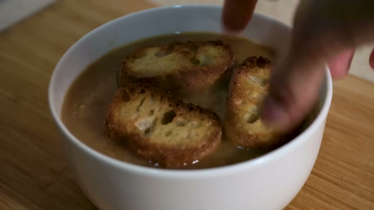 Colocando el pan tostado sobre la sopa